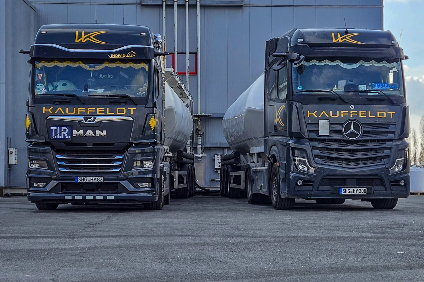Zwei Silotransporter der Firma Kauffeldt, dargestellt von vorn, werden befüllt